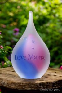 glazen urn in de kleuren roze en blauw met een naam en sterretjes gezandstraald