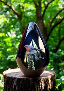 glazen urn met een groene askamer en een afbeelding van een roodborstje met een naam in zilver sign folie