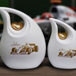 2 witte urnen met een bewerking van formule 1 racewagen in goud folie op de ur n