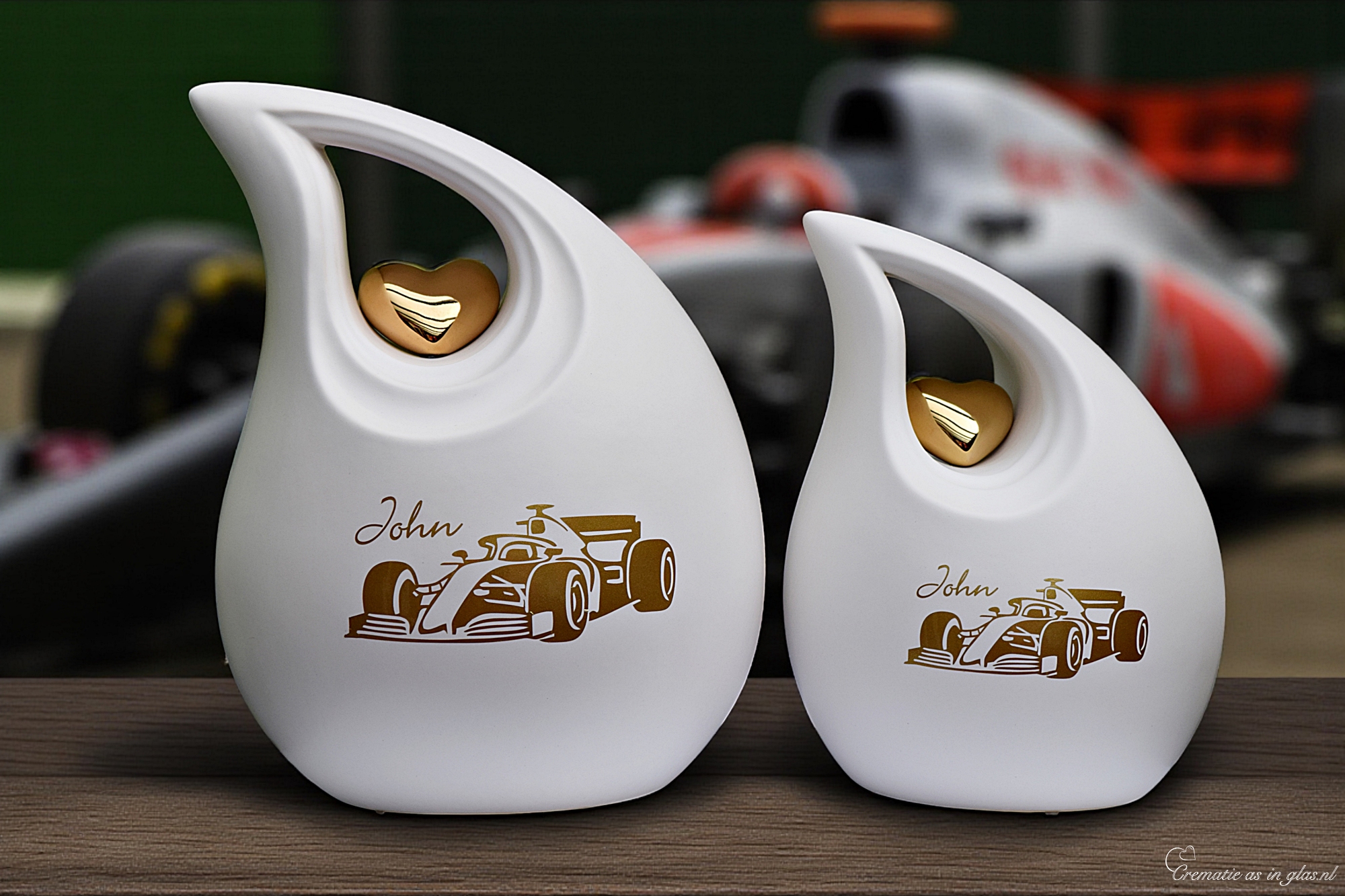 2 witte urnen met een bewerking van formule 1 racewagen in goud folie op de ur n