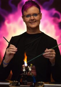 jet aan haar brander waar ze crematie-as in glas verwerkt in haar atelier