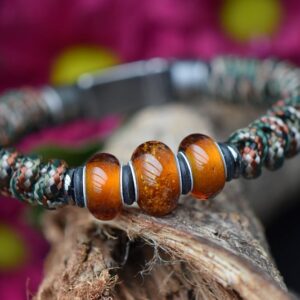 Heren gedenkarmband met woodland camo knoopwerk en drie transparant amber glasbedels waarvan de middelste crematie-as bevat.