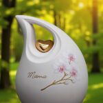 Weiße Keramikurne mit goldenem Herzen und rosa Orchidee, geeignet für Einäscherungsasche und Personalisierung mit kurzem Namen.